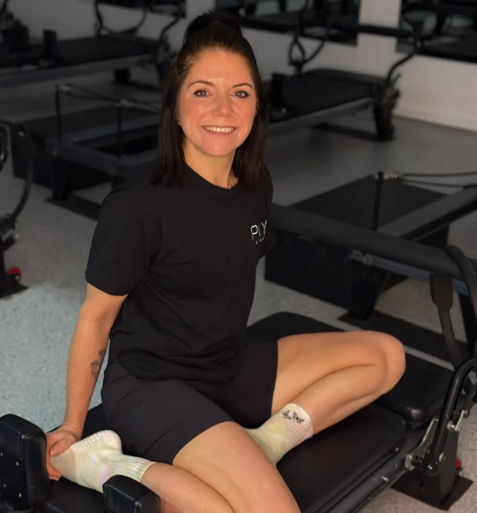 Vicky Hogan smiling with reformer Pilates machines visible in the background